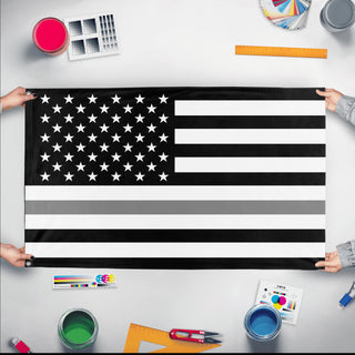 A mockup of the custom flag 'Thin Gray Line Flag' held up on a table during print checking