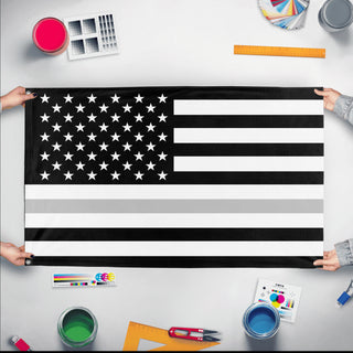 A mockup of the custom flag 'Thin Silver Line Flag' held up on a table during print checking