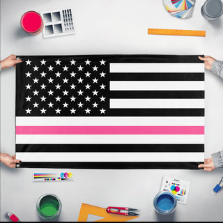 A mockup of the custom flag 'Thin Pink Line Flag' held up on a table during print checking