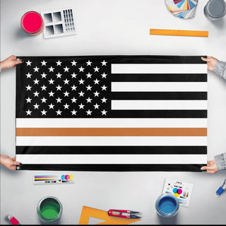 A mockup of the custom flag 'Thin Brown Line Flag' held up on a table during print checking