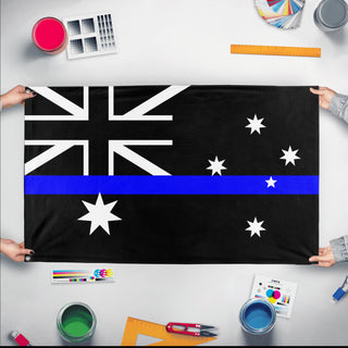 A mockup of the custom flag 'Thin Blue Line Australia Flag' held up on a table during print checking