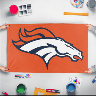 A mockup of the custom flag 'Denver Bronco Flag' held up on a table during print checking