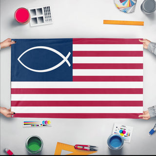 A mockup of the custom flag 'American Jesus Fish flag' held up on a table during print checking