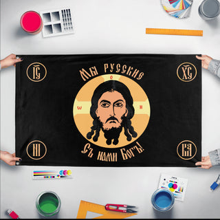 A mockup of the custom flag 'Holy Face of Christ Flag - Black flag' held up on a table during print checking