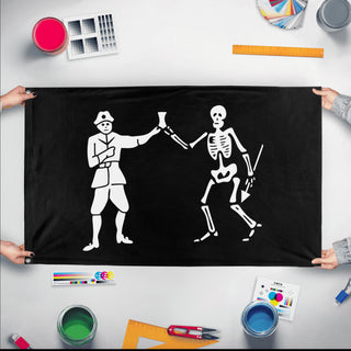 A mockup of the custom flag 'Black Bart Pirate Flag' held up on a table during print checking