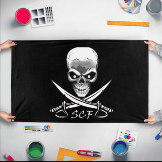 A mockup of the custom flag 'SCF flag' held up on a table during print checking