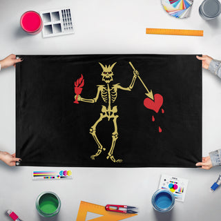 A mockup of the custom flag 'Blackbeard Demon Skeleton flag' held up on a table during print checking
