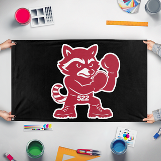 A mockup of the custom flag 'Fighting Racoons flag' held up on a table during print checking