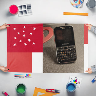 A mockup of the custom flag 'T flag' held up on a table during print checking