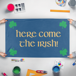 A mockup of the custom flag 'Here Come The Irish flag' held up on a table during print checking
