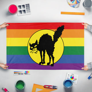 A mockup of the custom flag 'Pride Sabot Cat flag' held up on a table during print checking