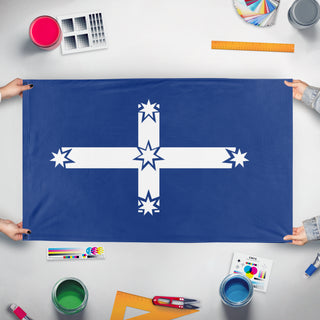 A mockup of the custom flag 'EUREKA! flag' held up on a table during print checking