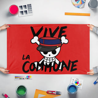 A mockup of the custom flag 'Once Piece Commune flag' held up on a table during print checking