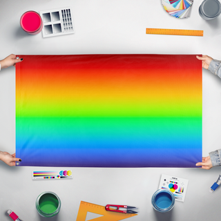 A mockup of the custom flag 'Continuous Spectrum flag' held up on a table during print checking