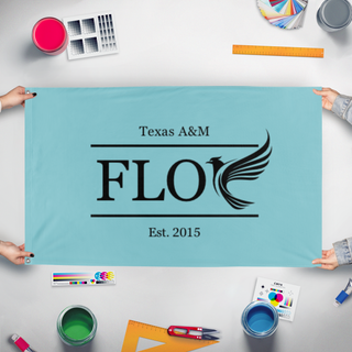 A mockup of the custom flag 'FLOC flag' held up on a table during print checking