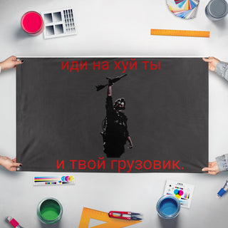 A mockup of the custom flag 'The QB flag' held up on a table during print checking