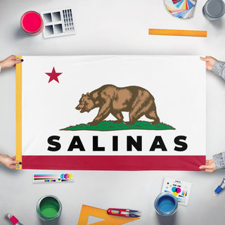 A mockup of the custom flag 'Salinas flag' held up on a table during print checking