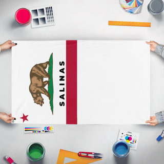 A mockup of the custom flag 'Cut salinas flag' held up on a table during print checking