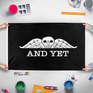 A mockup of the custom flag 'And yet flag' held up on a table during print checking
