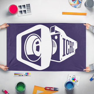 A mockup of the custom flag 'icrc flag' held up on a table during print checking