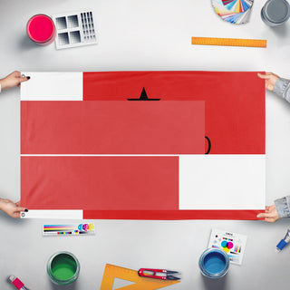 A mockup of the custom flag 'T flag' held up on a table during print checking