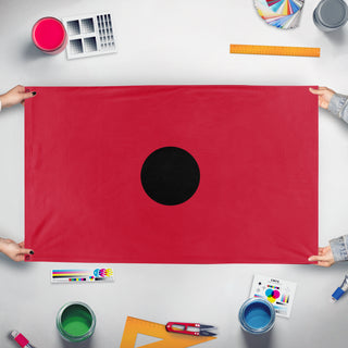 A mockup of the custom flag 'ANZAC Poppy flag' held up on a table during print checking