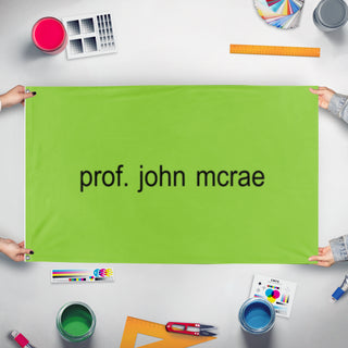 A mockup of the custom flag 'prof john  flag' held up on a table during print checking