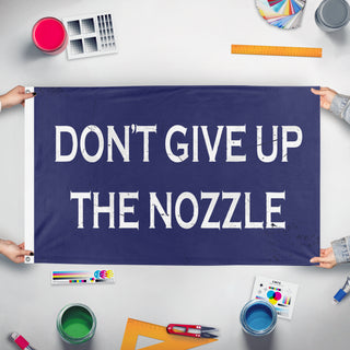 A mockup of the custom flag 'Don't Give Up the Nozzle flag' held up on a table during print checking