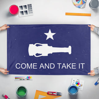 A mockup of the custom flag 'Come and Take It flag' held up on a table during print checking