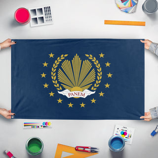 A mockup of the custom flag 'New Panem flag' held up on a table during print checking