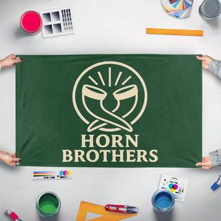 A mockup of the custom flag 'Horn Brothers flag' held up on a table during print checking