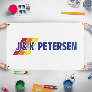 A mockup of the custom flag 'J&K flag' held up on a table during print checking