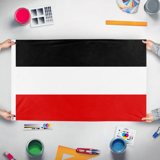 A mockup of the custom flag 'German Flag' held up on a table during print checking