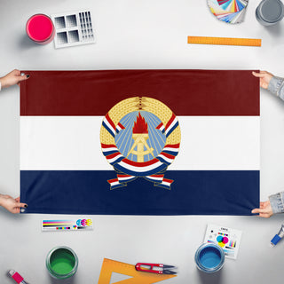 A mockup of the custom flag 'United Syndicalist Republic of Jasonia/U..S.R.J. flag' held up on a table during print checking