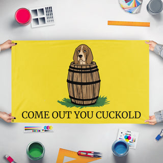 A mockup of the custom flag 'Come Out You Cuckold Gadsden flag' held up on a table during print checking