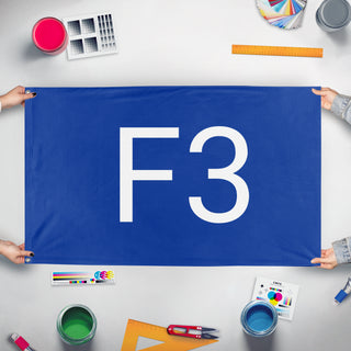 A mockup of the custom flag 'Flag of F3' held up on a table during print checking