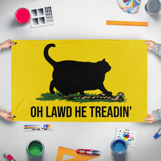 A mockup of the custom flag 'Oh Lawd he Treadin' flag' held up on a table during print checking