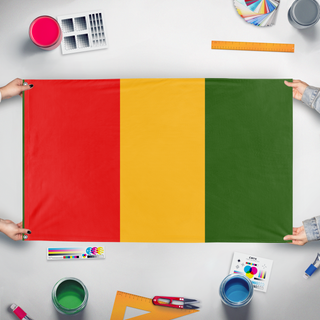 A mockup of the custom flag 'gunea flag' held up on a table during print checking