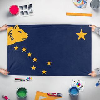 A mockup of the custom flag 'Alaska Redesign  flag' held up on a table during print checking