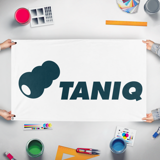 A mockup of the custom flag 'taniq flag' held up on a table during print checking