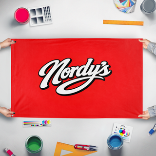 A mockup of the custom flag 'nordys flag' held up on a table during print checking