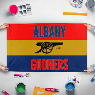 A mockup of the custom flag 'Gooners Flag' held up on a table during print checking