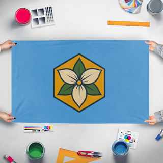 A mockup of the custom flag 'Trillium flag' held up on a table during print checking