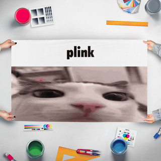 A mockup of the custom flag 'plink flag' held up on a table during print checking