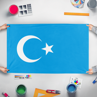 A mockup of the custom flag 'Flag of Uyghurs' held up on a table during print checking