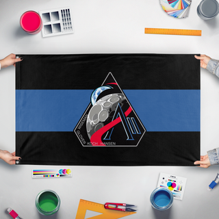 A mockup of the custom flag 'Artimis 2 flag' held up on a table during print checking