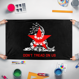 A mockup of the custom flag 'Lib-Soc Gadsden flag' held up on a table during print checking