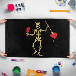 A mockup of the custom flag 'Golden Blackbeard flag' held up on a table during print checking