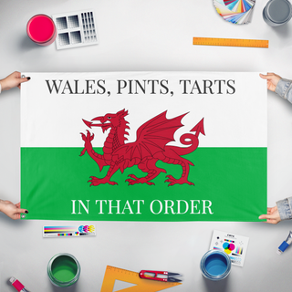 A mockup of the custom flag 'welshtarts flag' held up on a table during print checking