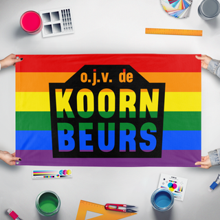 A mockup of the custom flag 'Koornbeurs Pride flag' held up on a table during print checking